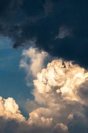 Puffy ivory and beige clouds with a light and dark blue sky