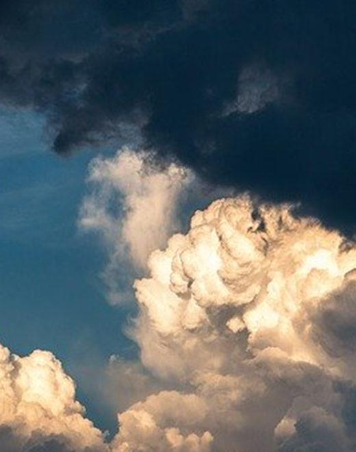 Puffy ivory and beige clouds with a light and dark blue sky