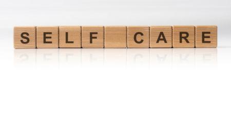 Scrabble letters spelling "self care" against a white background.