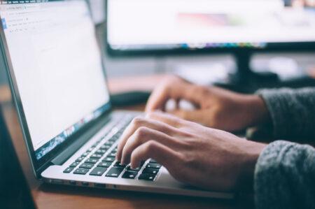 Person typing on laptop.