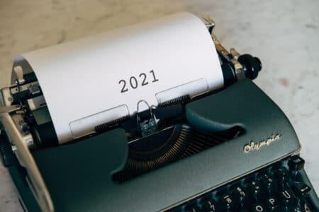 Typewriter with piece of paper sticking out with numbers 2021 typed on it.