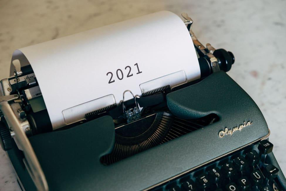 Typewriter with piece of paper sticking out with numbers 2021 typed on it.