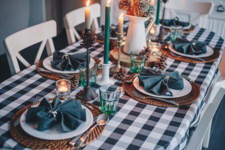 A table with fancy plates and napkins and candles lit.