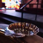 A silver shell on the edge of a baptismal font