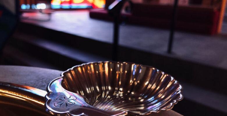 A silver shell on the edge of a Baptismal font.