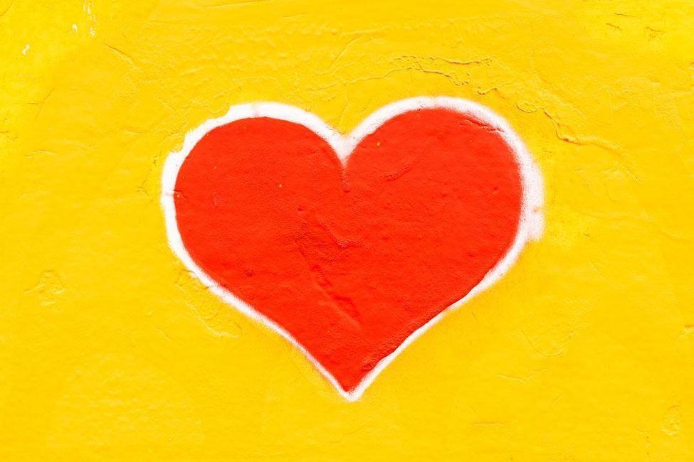 Red heart with white outline on yellow background.