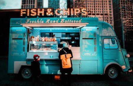 Two people at a Fish and Chips food truck.