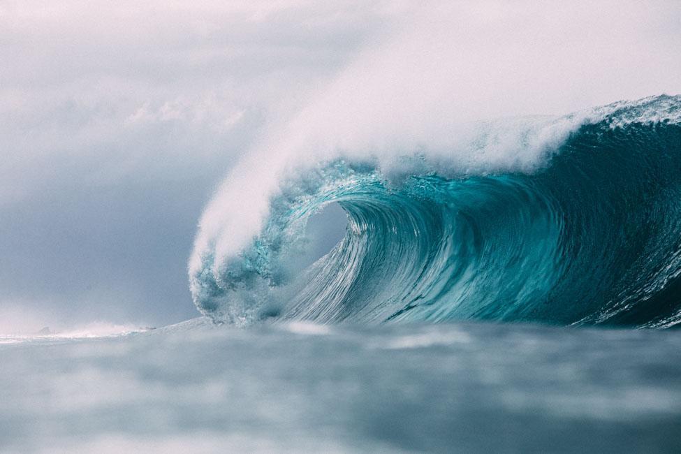 Large ocean wave with white foam on top.