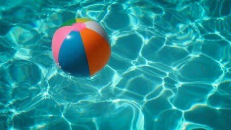Beach ball in turquoise pool water.