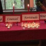 A table with a red table cloth, words such as knowledge, and candles.