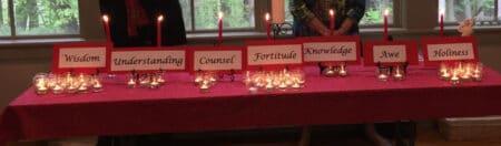 A table with a red table cloth, words such as knowledge, and candles.