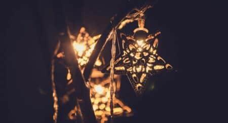 Close-up of string of white lights with stars in front of a dark background