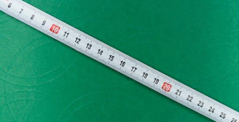 Measuring tape showing numbers from 6 to 26 positioned diagonally in front of green background