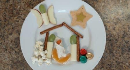 White plate with various foods and a star arranged to look like a nativity scene