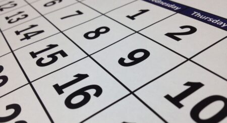 Close-up diagonal view of black-and-white monthly numbered calendar, showing numbers 1, 2, 6, 7, 8, 9, 10, 12, 13, 14, 15, 16