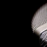 Close-up of silver microphone on the right against a black background