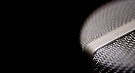 Close-up of silver microphone on the right against a black background