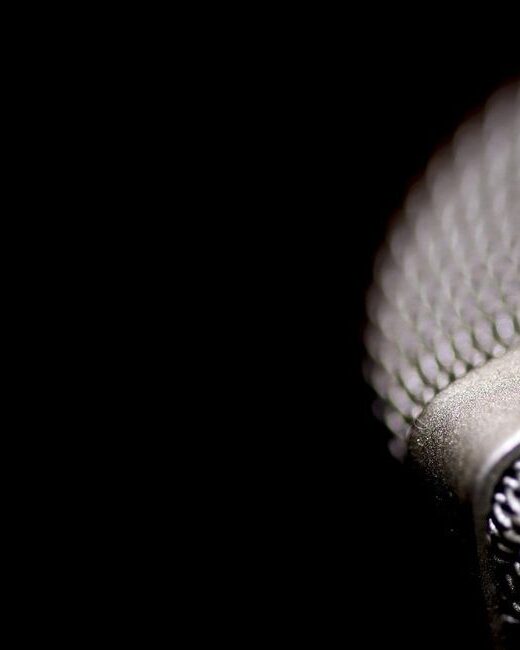 Close-up of silver microphone on the right against a black background