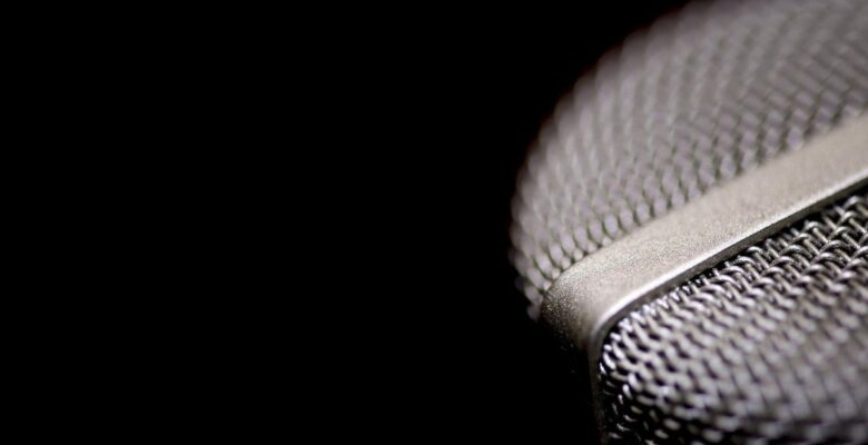 Close-up of silver microphone on the right against a black background