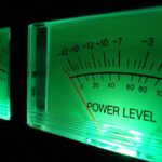 Close-up of volume level meter with green front lighting against a dark background