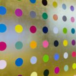 Circular dots of various colors aligned in rows and columns on a gold surface