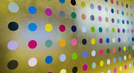 Circular dots of various colors aligned in rows and columns on a gold surface