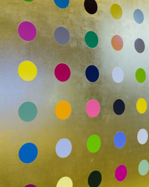 Circular dots of various colors aligned in rows and columns on a gold surface