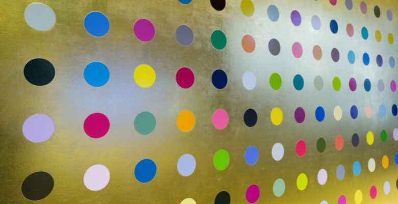Circular dots of various colors aligned in rows and columns on a gold surface