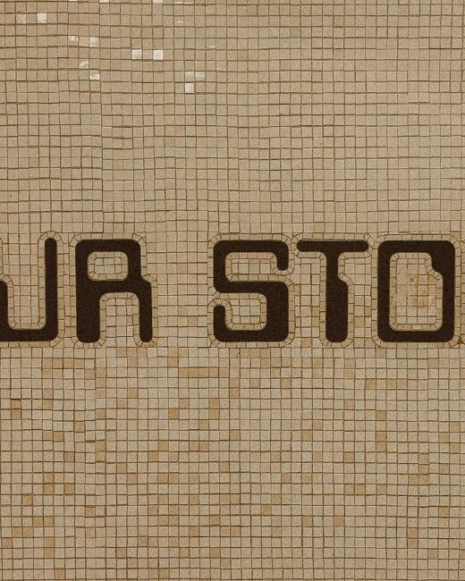 Text that says "YOUR STORY" in dark brown vintage video game letters on a beige tile wall